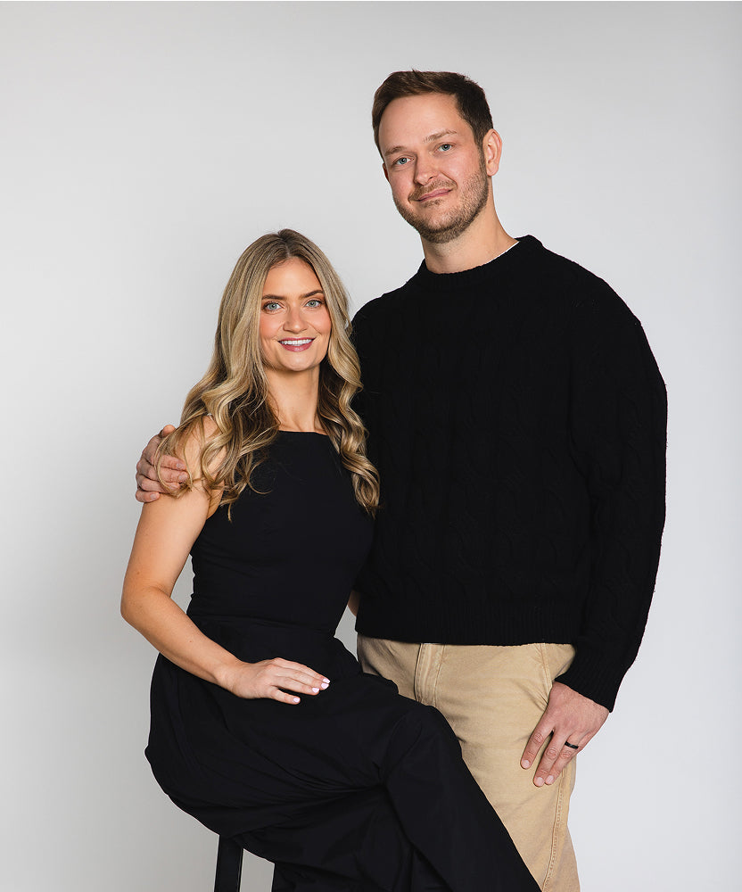 BoulderBio husband and wife founder team with Rachel seated and Henry standing by her with arm around her, gray background