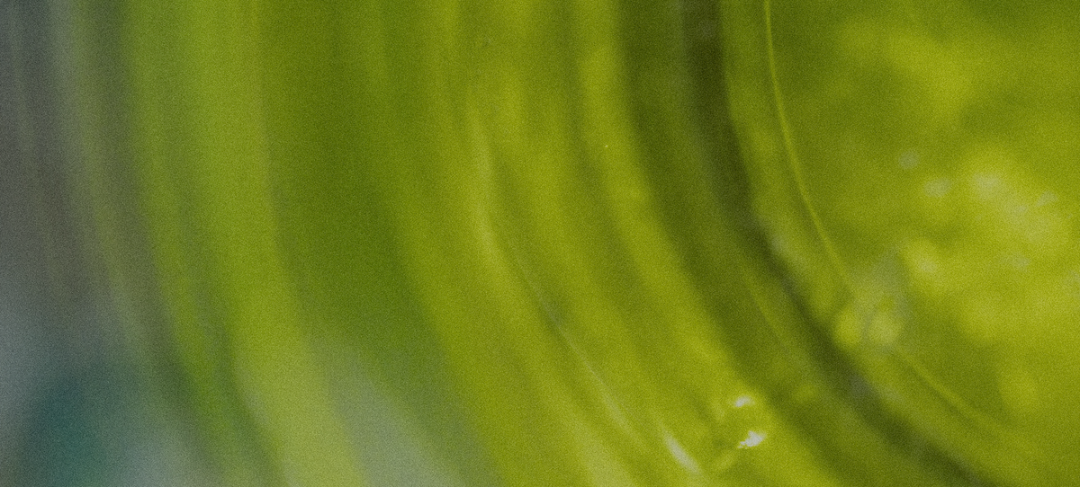 Close-up of a green glass container with swirling patterns