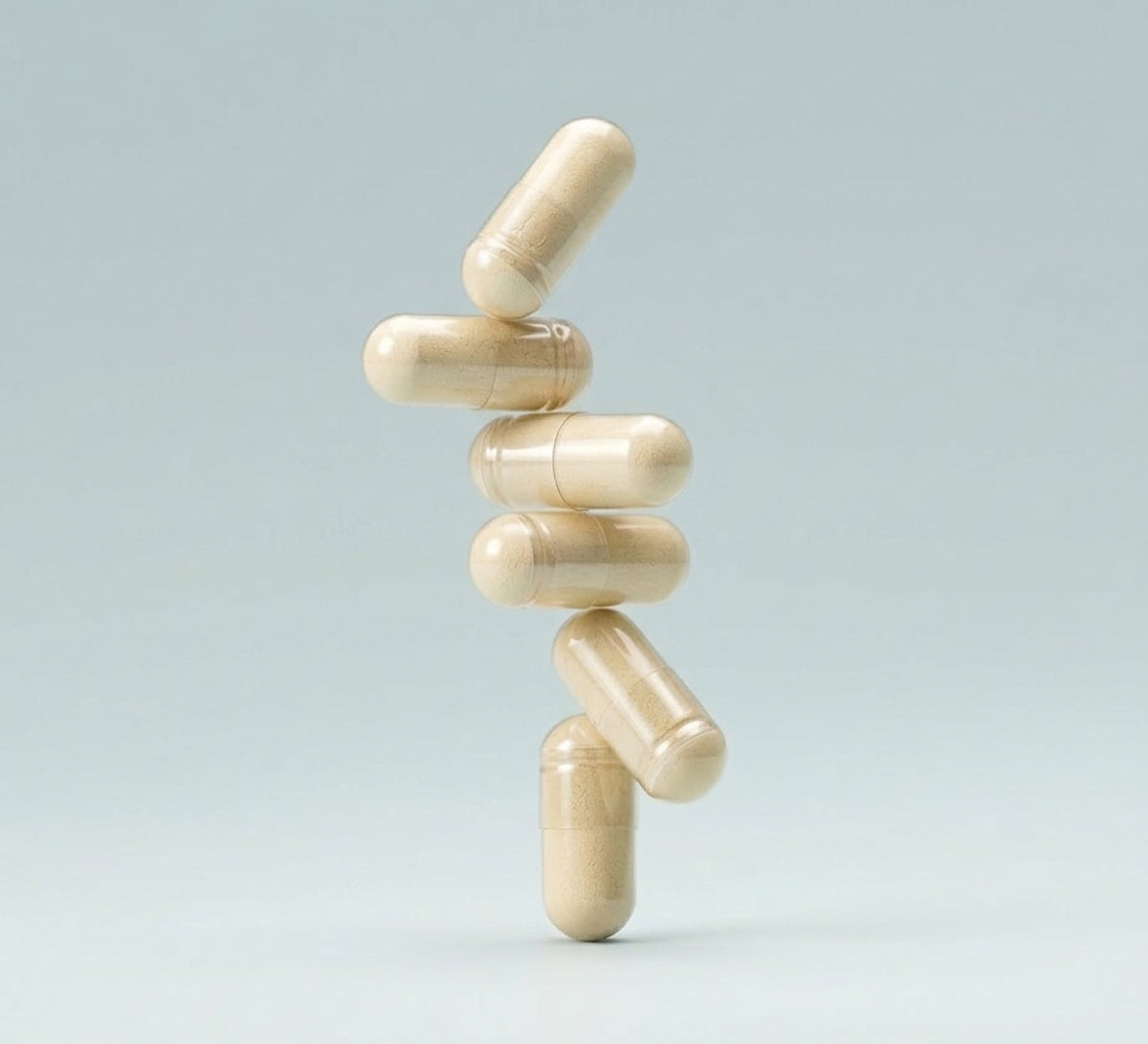 Stack of beige digestive enzyme capsules floating against a pale blue background.